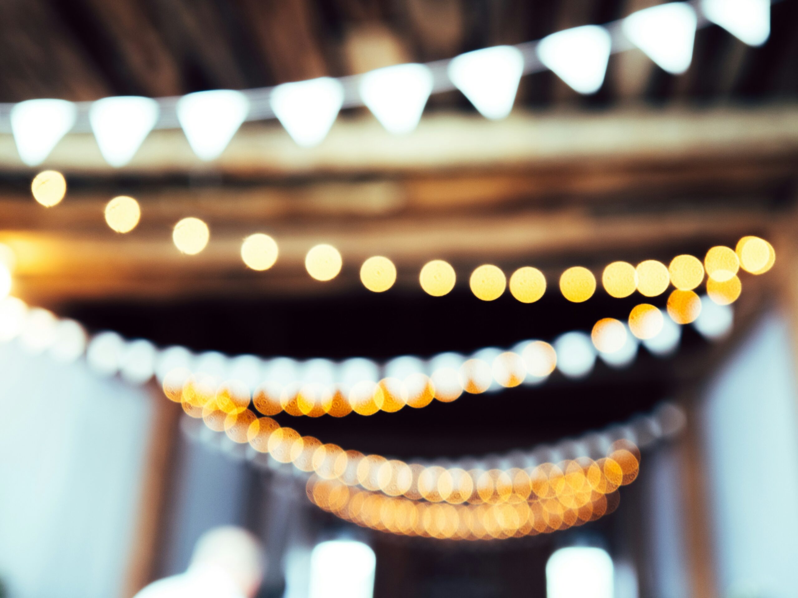 out of focus twinkle lights hang within an event venue