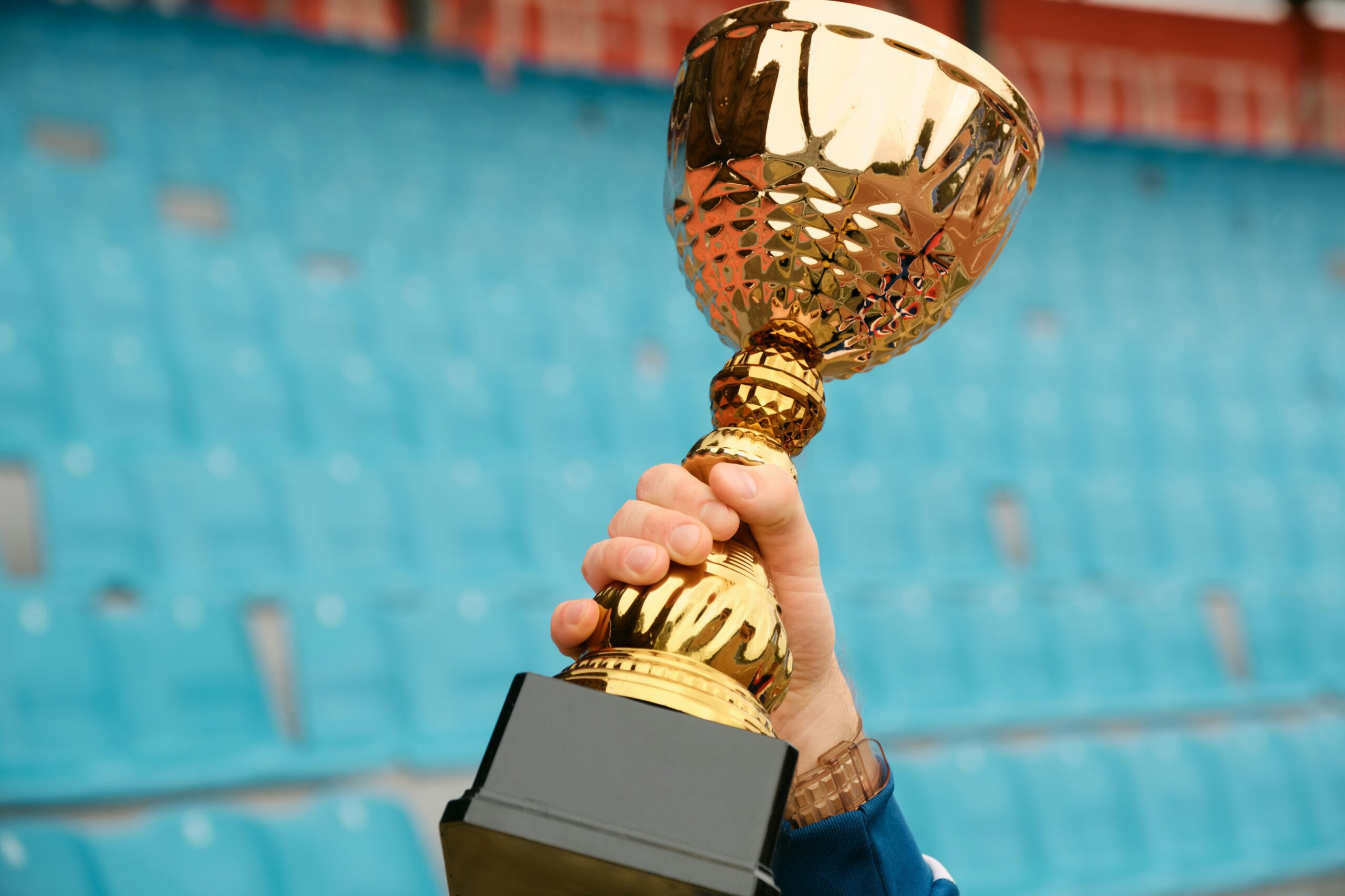 A person holds a golden trophy aloft to symbolize winning a charity sweepstakes