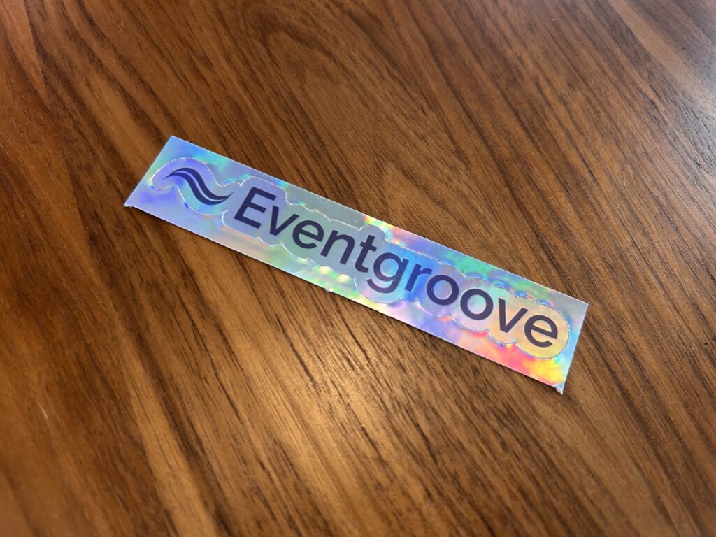 A holographic kiss cut sticker of the Eventgroove logo